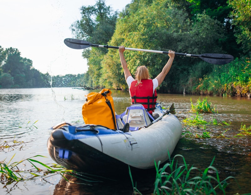 A woman celebrating in an inflatable kayak