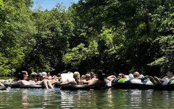A Group Of People Tubing Down A River