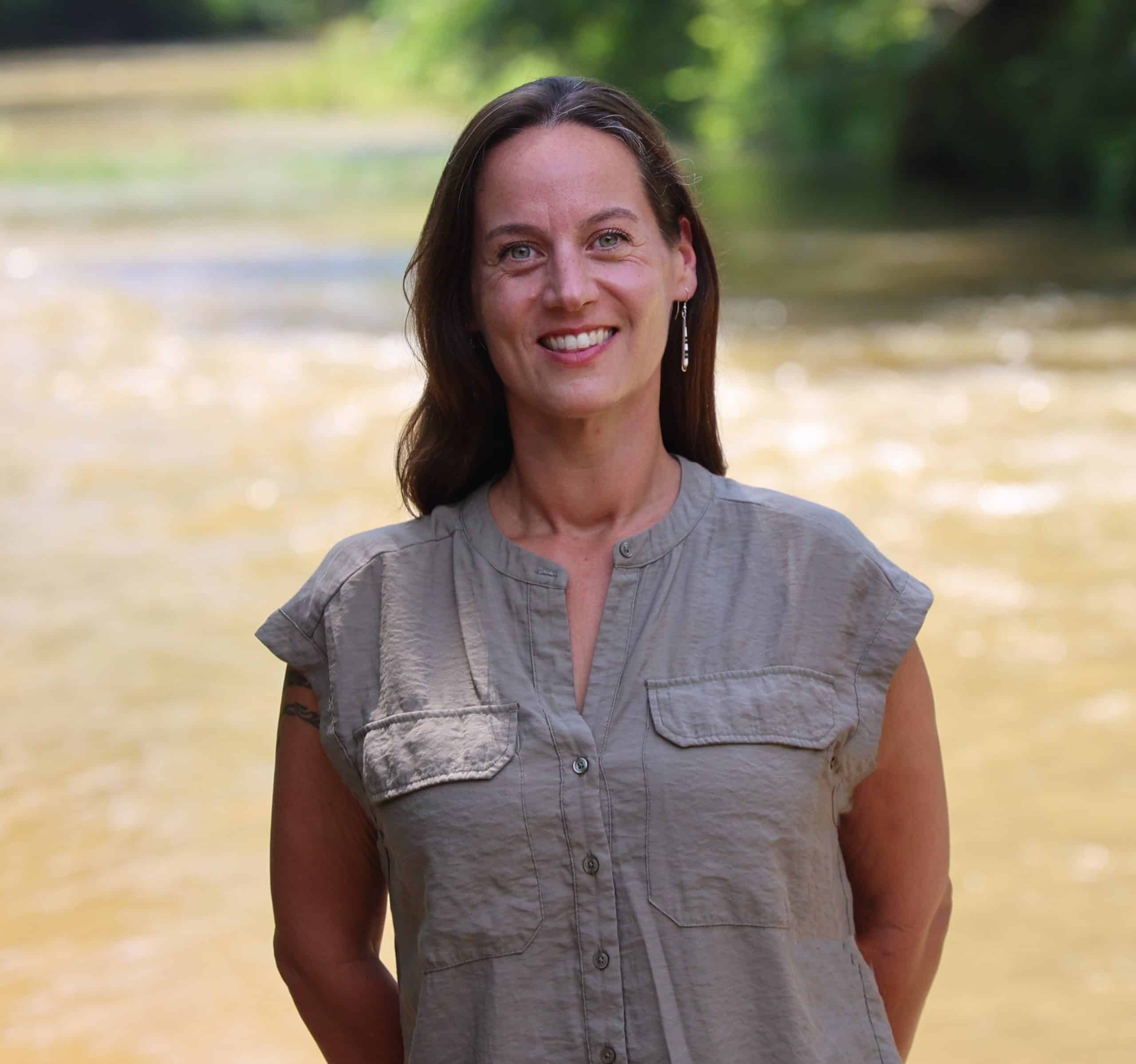 a woman standing next to a body of water