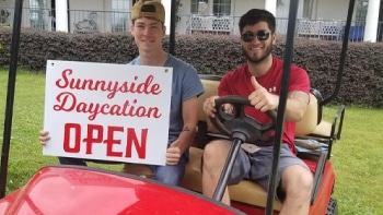 Employees holding a Sunnyside Daycation sign