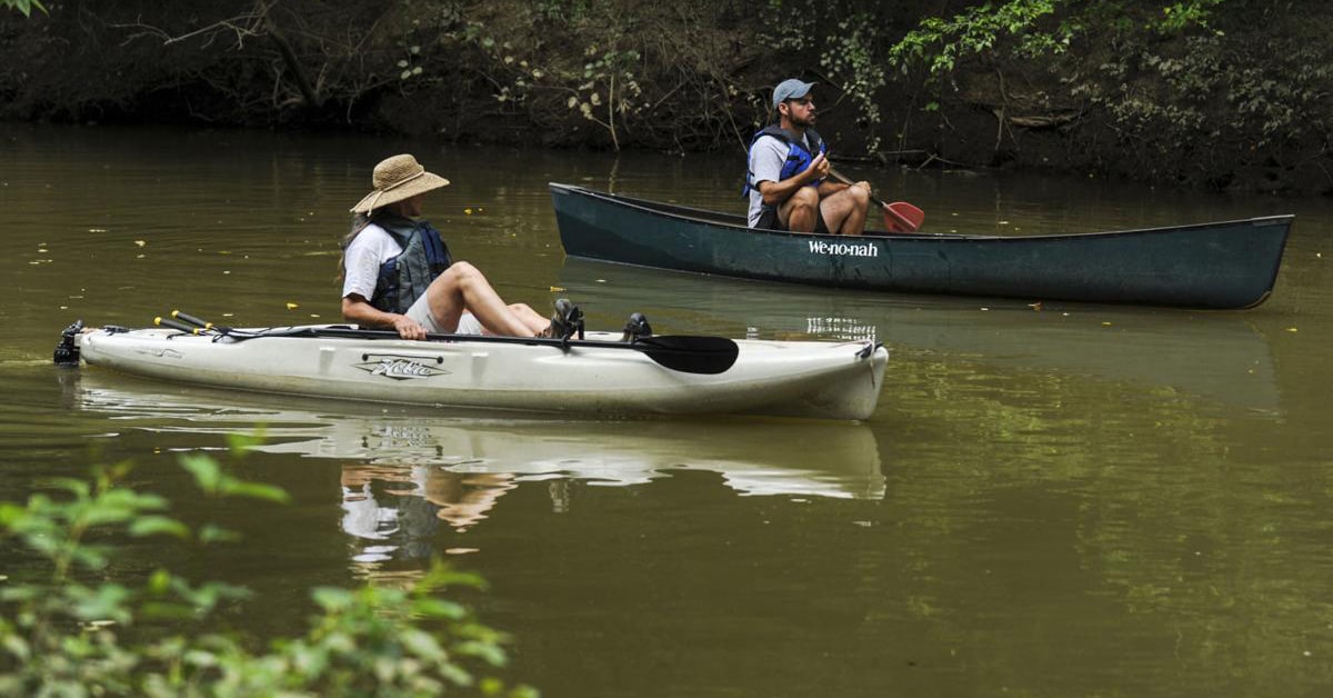 A Couple Kayaking Down A River