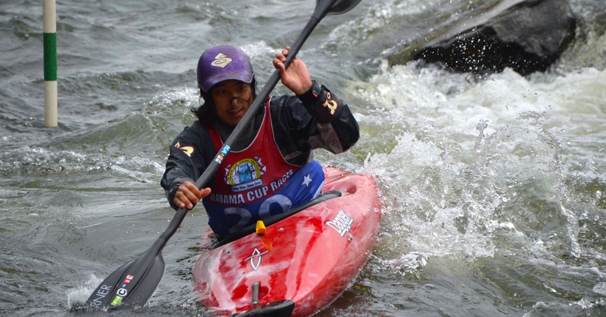 A Man Kayaking Through Rapids