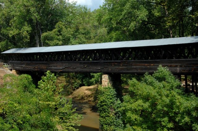 A Bridge Over A River In A Forest