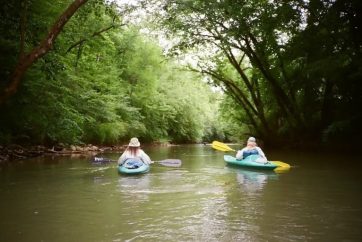 Friends Kayaking Down A River