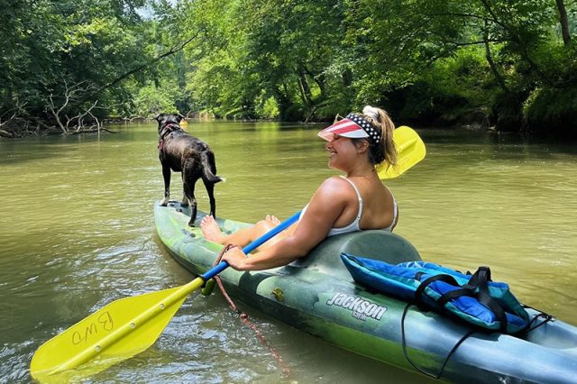 A Woman Kayaking With Her Dog