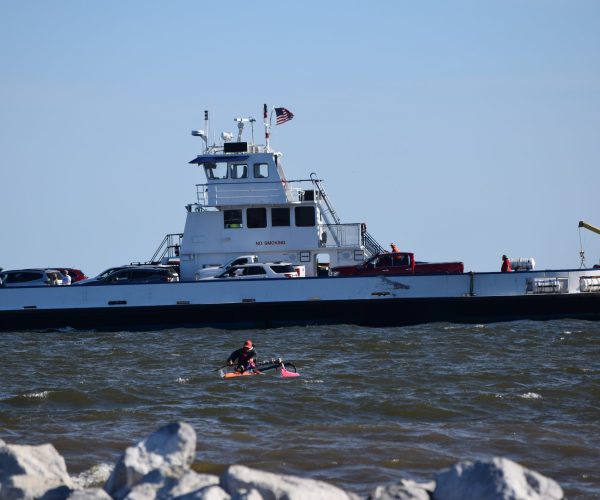 Kayaker Paddling Near A Ship In The Ocean