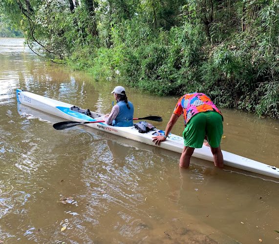 A Group Of People Rowing A Boat In The Water