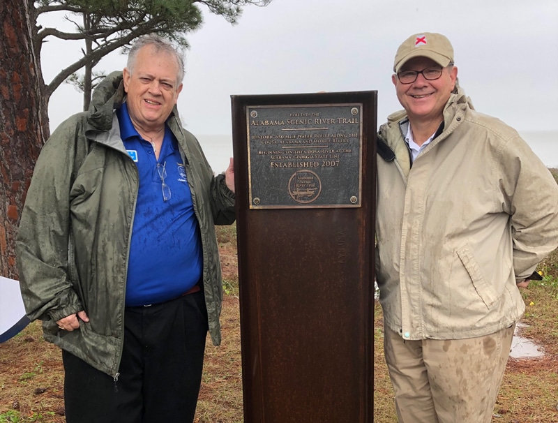 Two men standing near an Alabama Scenic River Trail plaque