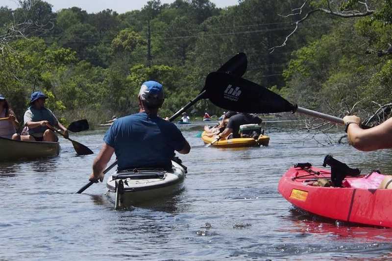 People kayaking down a river