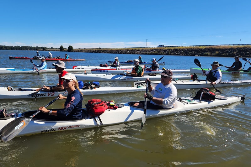 A Group Of People Rowing In A River