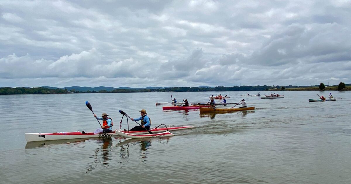 A Group Of People Kayaking In A River