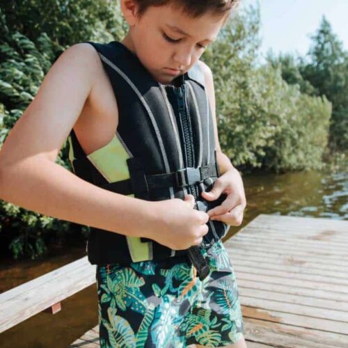 A kid putting on a life jacket