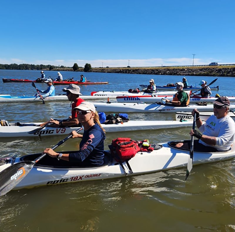 A group of people rowing a boat in a river