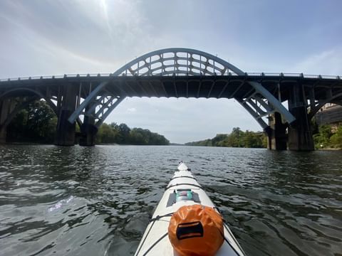 Kayaker approaching a bridge