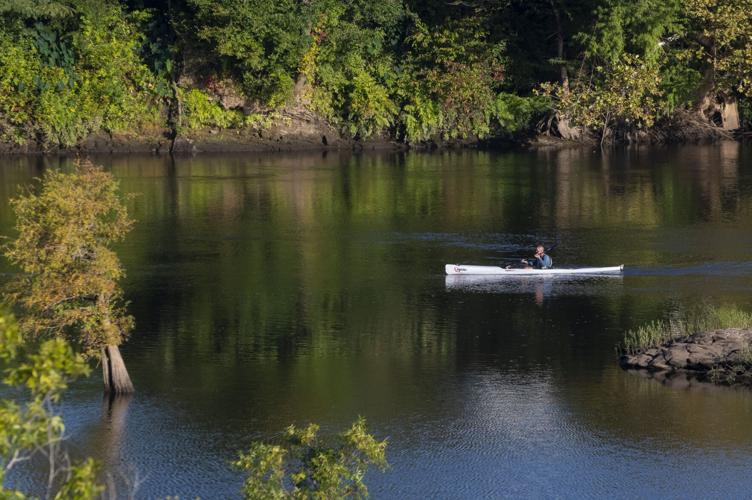 A Man Kayaking Down A River