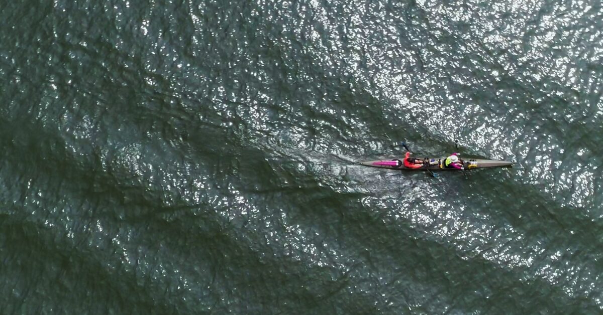 A Person Riding A Wave On Top Of A Body Of Water