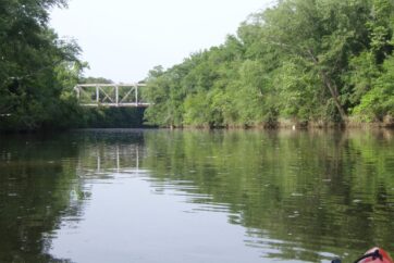 Kayak on a river flowing under a bridge