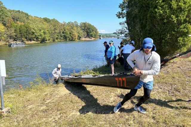 Men Pulling Their Tandem Kayak Out Of A River