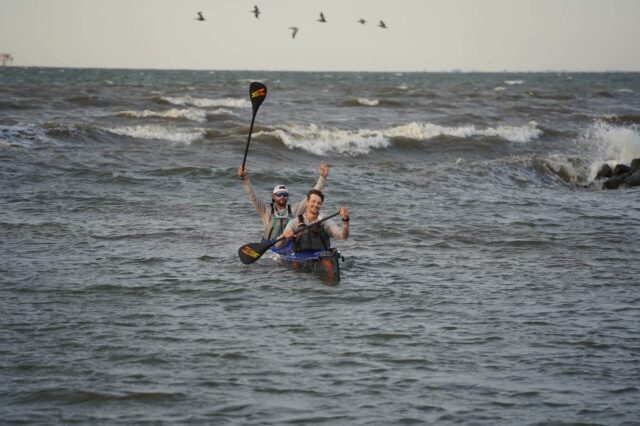 Two Men Kayaking With A Tandem Boat In The Ocean
