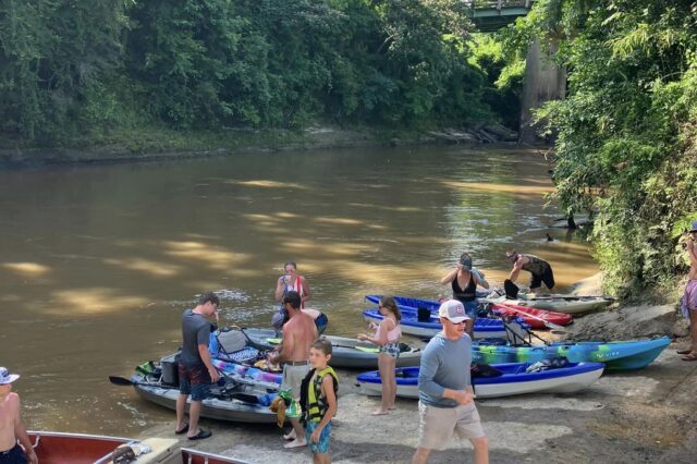 a group of people about to get on their kayaks in the water
