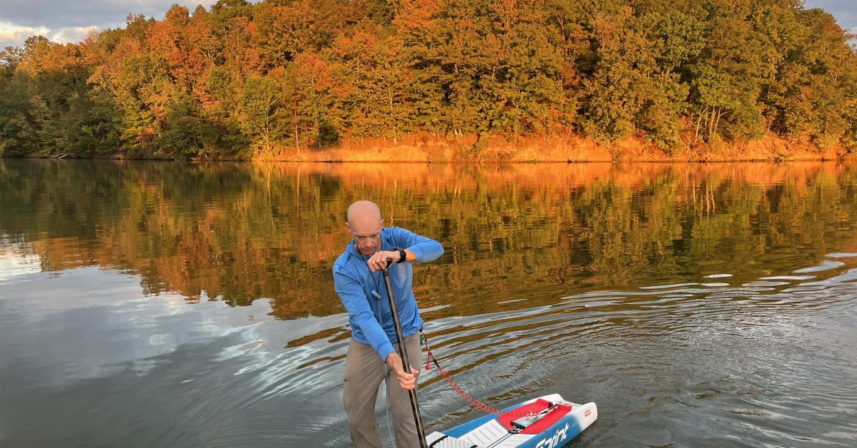 a man riding on the back of a boat in a body of water
