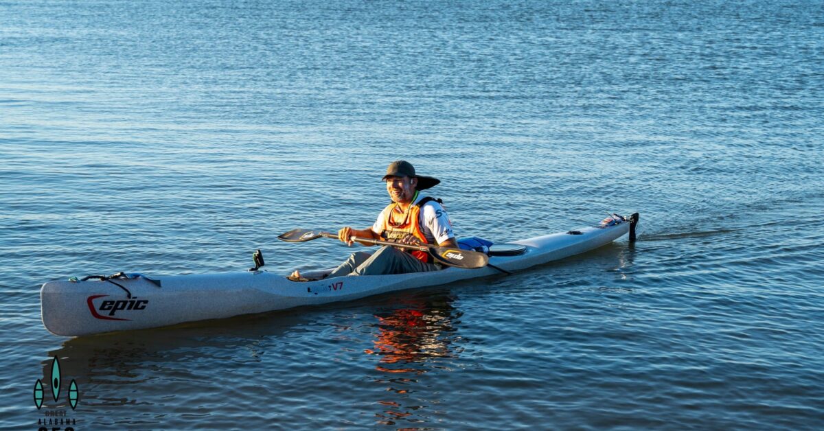 a group of people riding on the back of a boat in the water