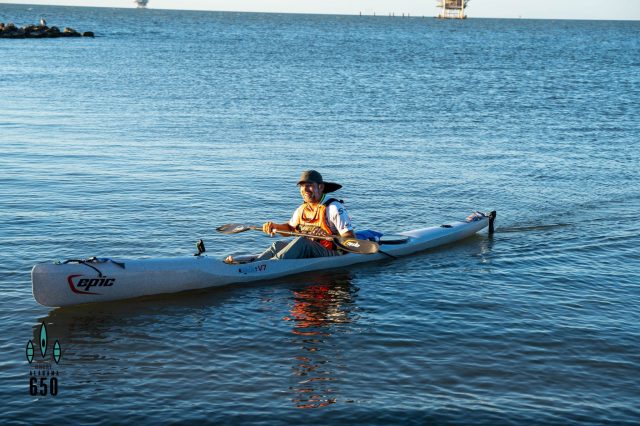 a group of people riding on the back of a boat in the water